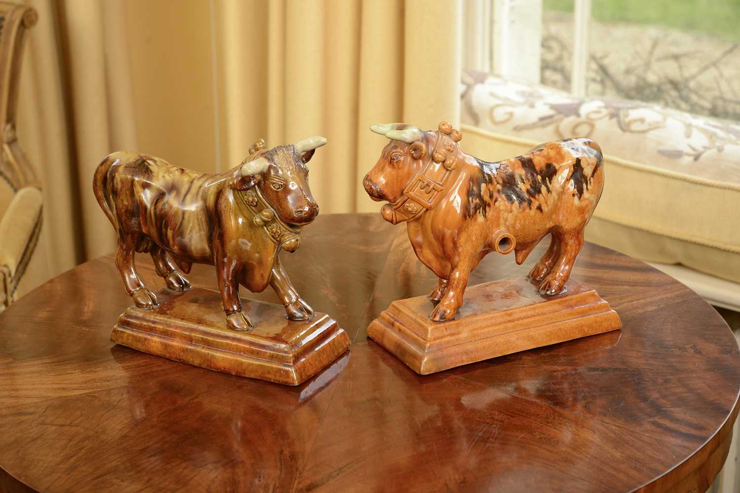 Lot 88 - A pair of treacle-glazed pottery bulls