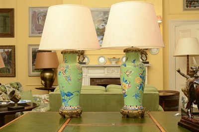 Lot 84 - A pair of chinoiserie-decorated pottery and gilt metal mounted table lamps