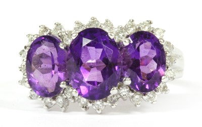 Lot 290 - A 9ct white gold amethyst and diamond triple cluster ring