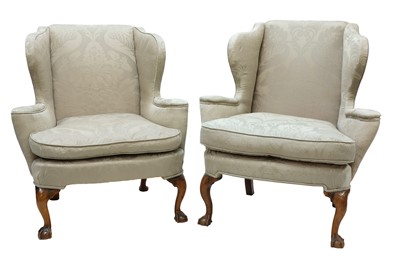 Lot 395 - A closely matched pair of George III-style wing back armchairs