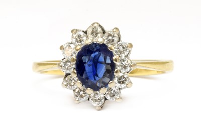 Lot 114 - An 18ct gold sapphire and diamond oval cluster ring
