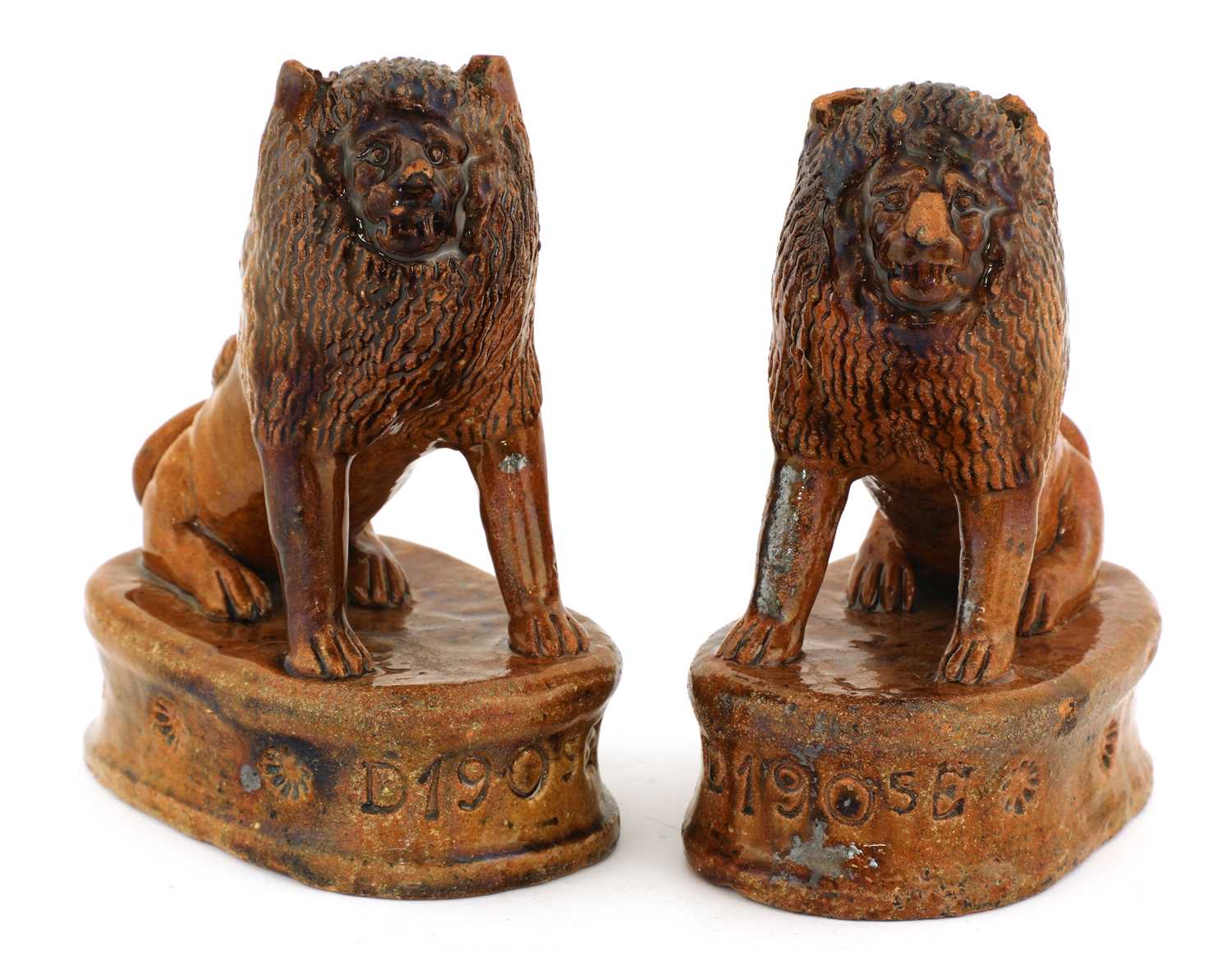 Lot 68 - A pair of treacle-glazed pottery lions