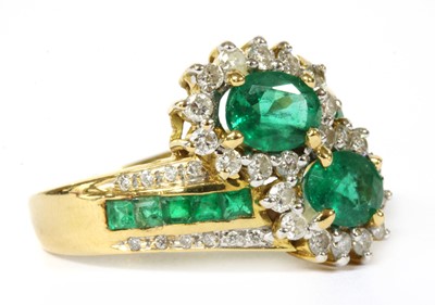 Lot 161 - An 18ct gold emerald and diamond cluster crossover ring