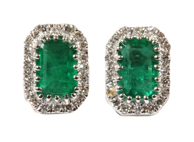 Lot 149 - A pair of white gold emerald and diamond cluster earrings