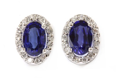 Lot 106 - A pair of white gold sapphire and diamond cluster earrings