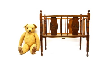Lot 115 - An old teddy bear in a wooden cot