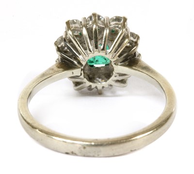 Lot 357 - A white gold emerald and diamond cluster ring