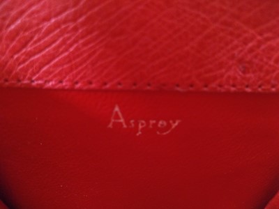 Lot 103 - An Asprey deep coral coloured ostrich leather coin purse