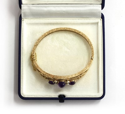 Lot 133 - A 9ct gold amethyst and split pearl bangle