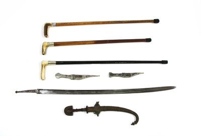 Lot 71A - Three Eastern daggers in scabbards, a sword blade and three walking sticks