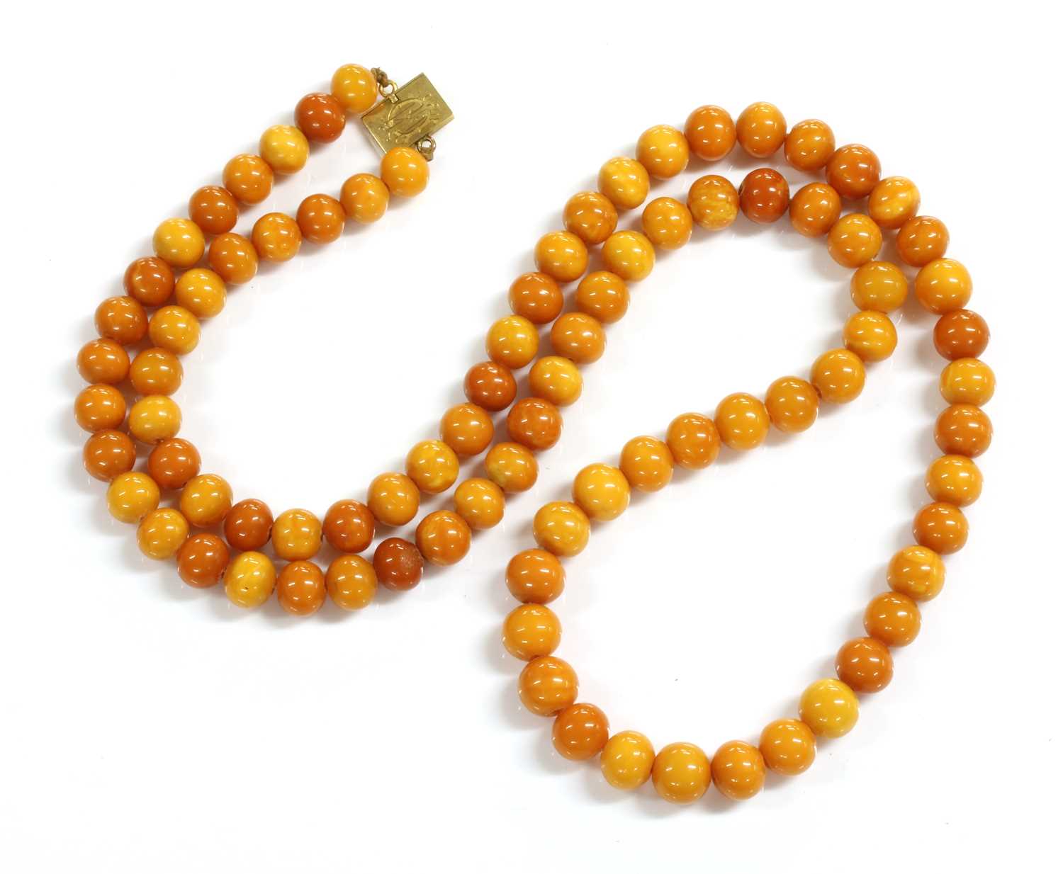 Lot 71 - A single row uniform spherical butterscotch amber bead necklace