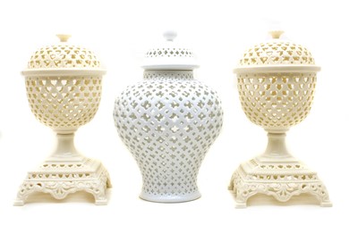 Lot 391 - A pair of modern pierced creamware lidded urns