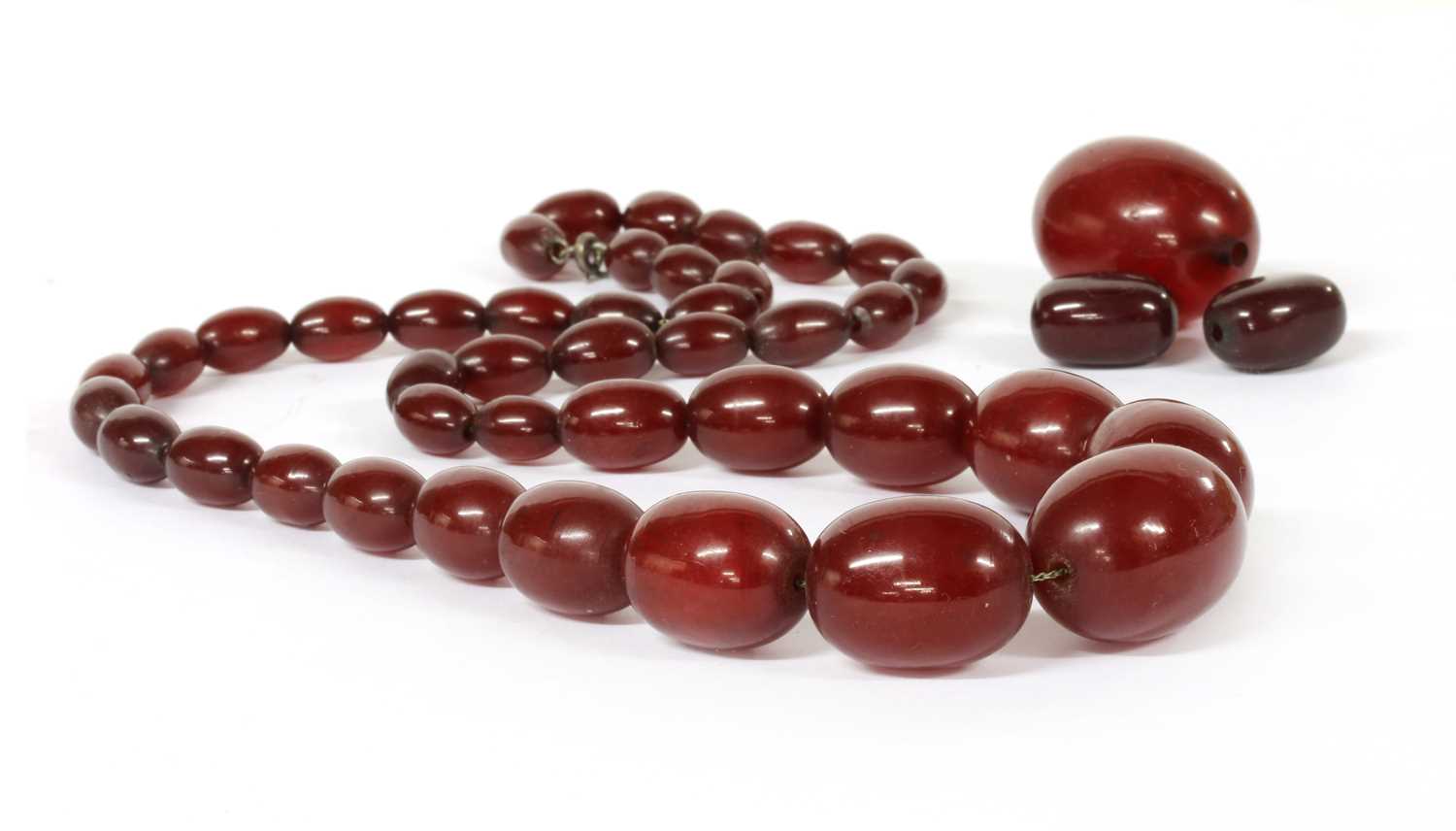 Lot 43 - A single row graduated cherry coloured Bakelite bead necklace