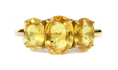 Lot 231 - A gold three stone yellow sapphire ring
