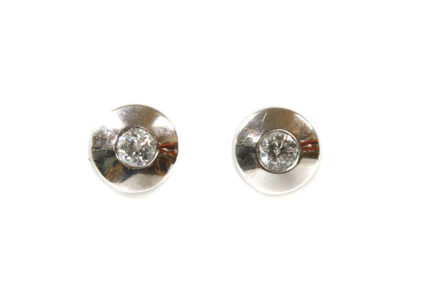 Lot 102 - A pair of white gold single stone diamond stud earrings