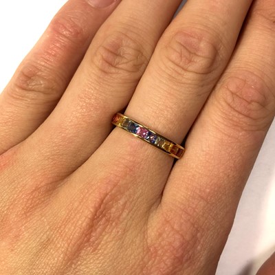 Lot 176 - A gold rainbow sapphire half eternity ring