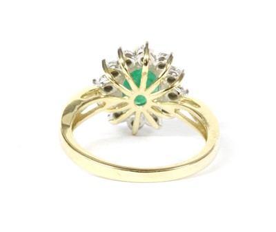 Lot 100 - A gold emerald and diamond cluster ring