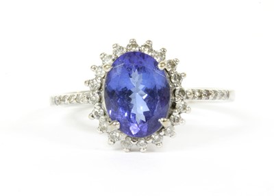 Lot 243 - An 18ct white gold tanzanite and diamond halo cluster ring