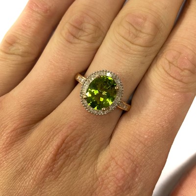 Lot 150 - A gold peridot and diamond cluster ring