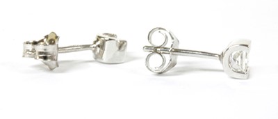 Lot 103 - A pair of white gold single stone diamond stud earrings