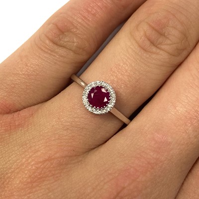 Lot 122 - A white gold ruby and diamond halo cluster ring