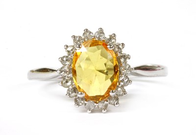 Lot 174 - A white gold yellow sapphire and diamond cluster ring