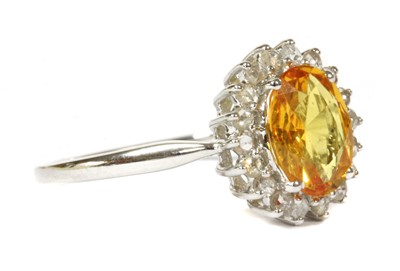 Lot 174 - A white gold yellow sapphire and diamond cluster ring