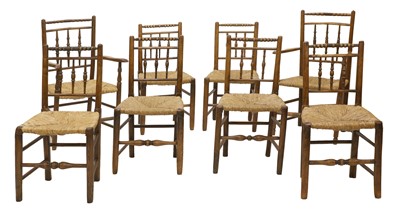 Lot 729 - A matched set of eight oak and elm rush seated chairs