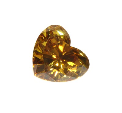 Lot 486 - An unmounted fancy orangey yellow heart shaped brilliant cut diamond