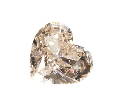Lot 484 - An unmounted fancy yellowish pink heart shaped brilliant cut diamond