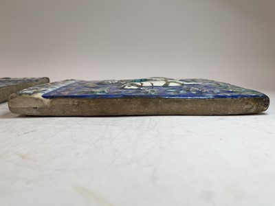 Lot 947 - A near pair of Qajar pottery tiles