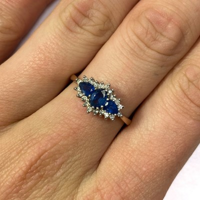 Lot 109 - A 9ct gold sapphire and diamond three stone cluster ring