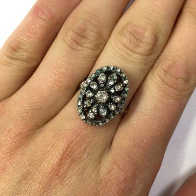 Lot 132 - A gold and silver diamond oval cluster ring