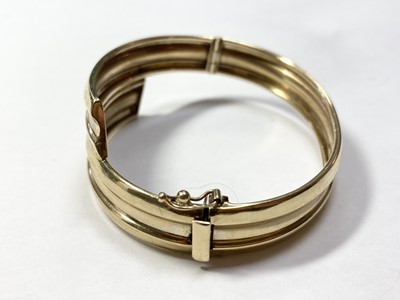 Lot 46 - A 9ct gold oval hinged crossover bangle