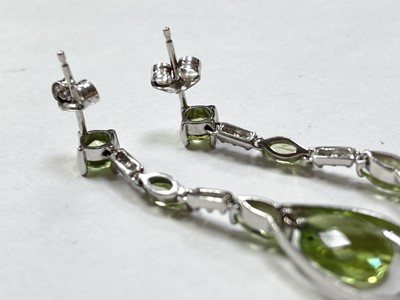 Lot 315 - A pair of 9ct white gold peridot and diamond drop earrings