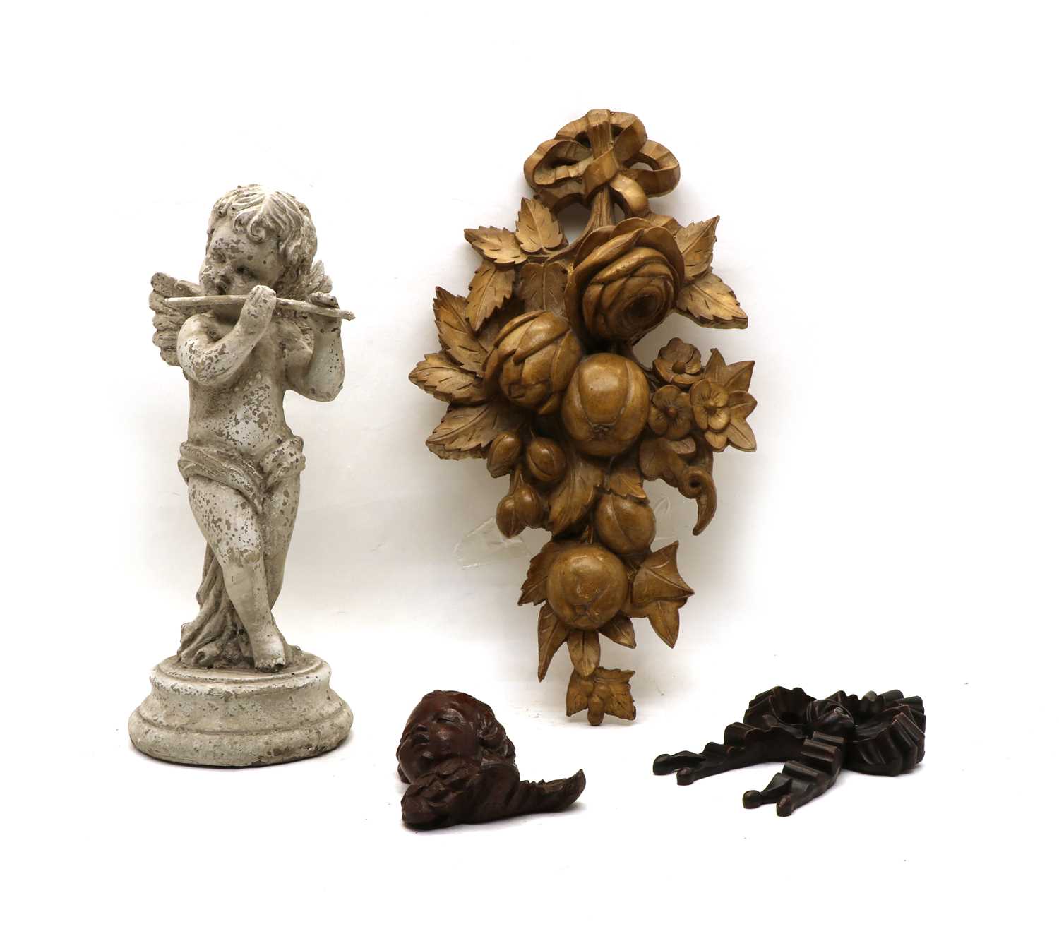 Lot 31 - A carved and painted wooden figure of a cherub playing a flute