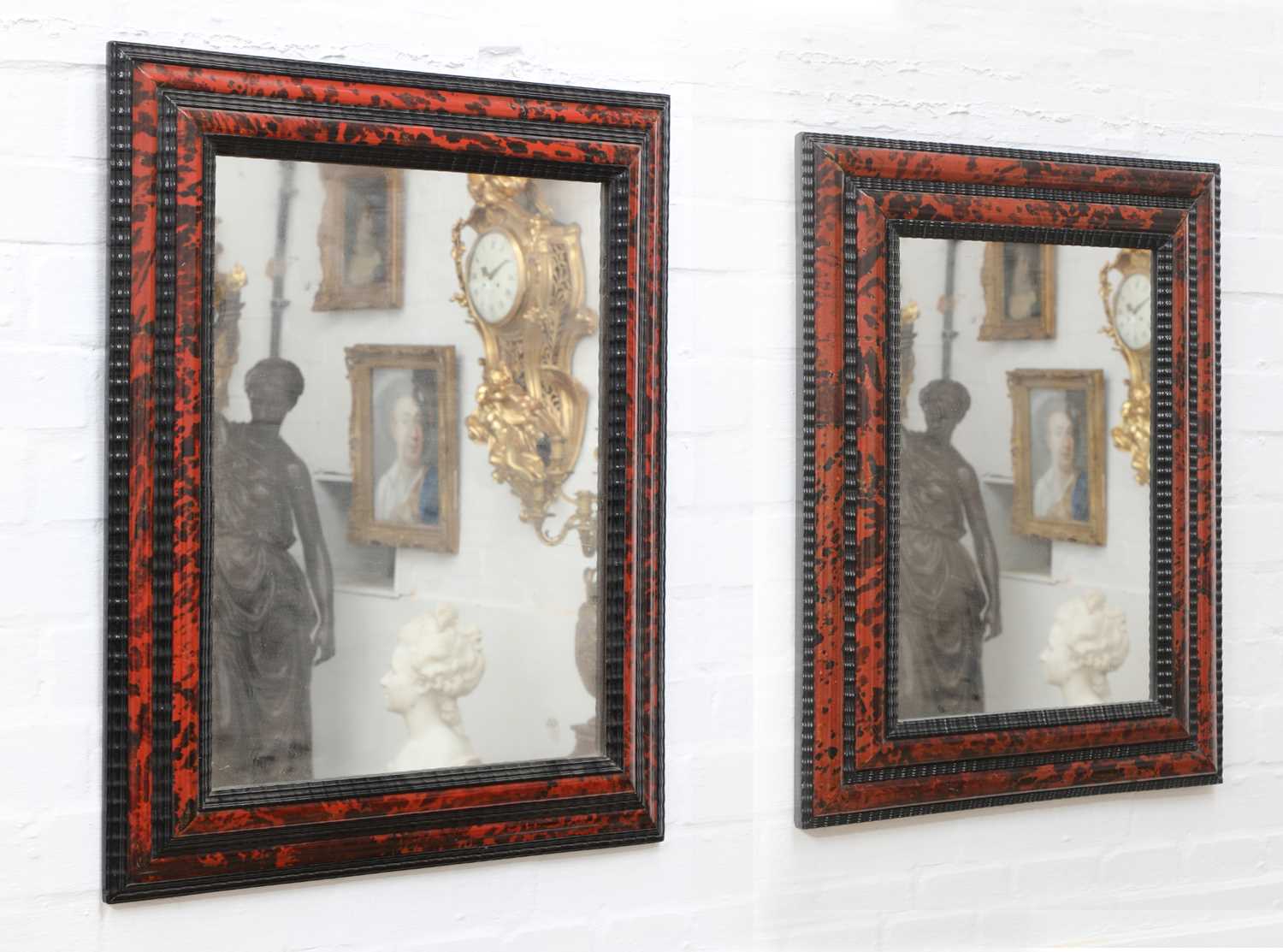 Lot 118 - Two similar red tortoiseshell and ebonised wall mirrors