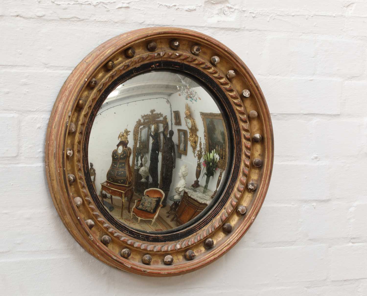 Lot 357 - A George III-style gilt-framed convex wall mirror