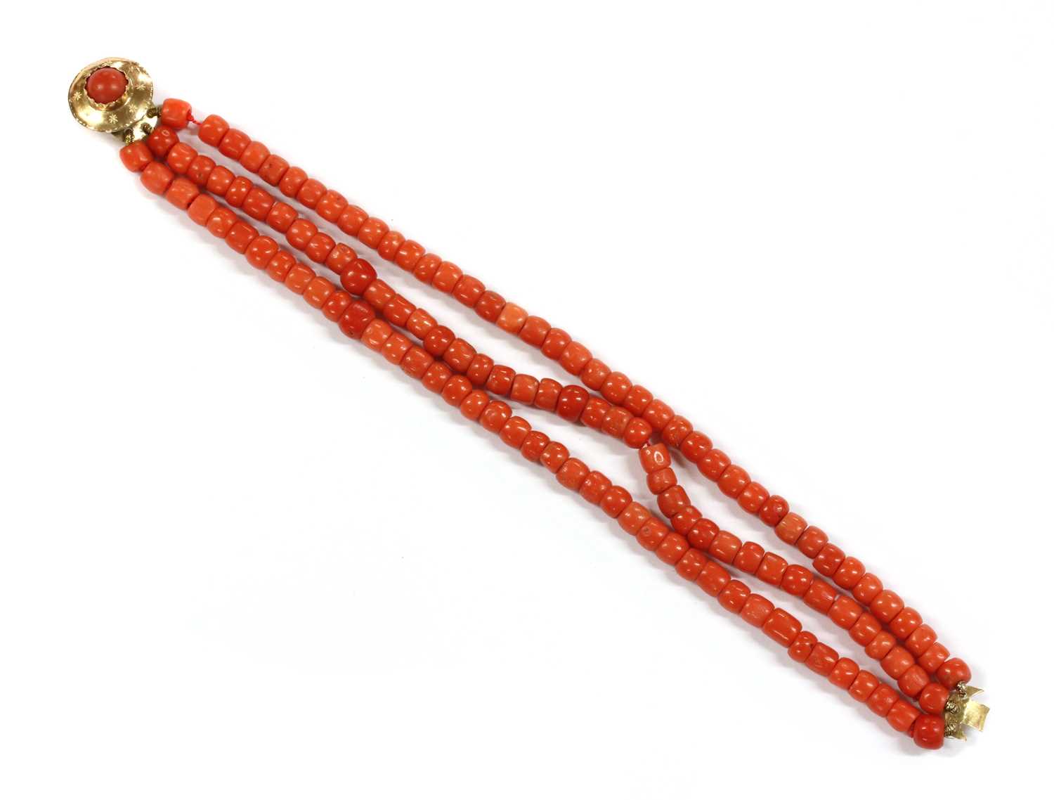 Lot 23 - A three row uniform coral bead bracelet