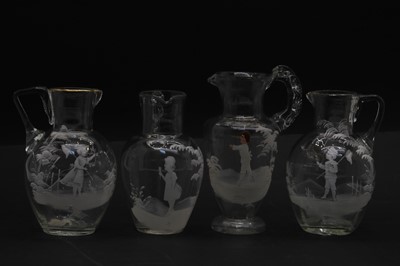 Lot 59 - Five clear glass 'Mary Gregory' jugs