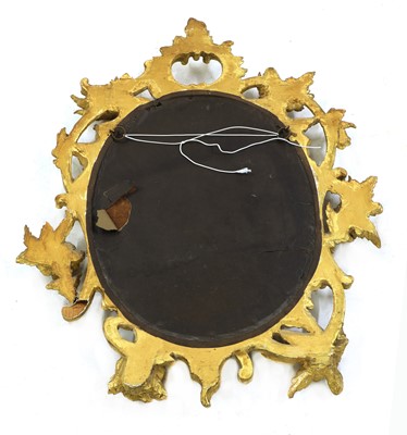 Lot 218 - A carved giltwood rococo-style oval mirror