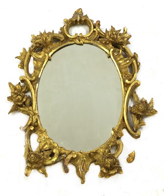 Lot 218 - A carved giltwood rococo-style oval mirror