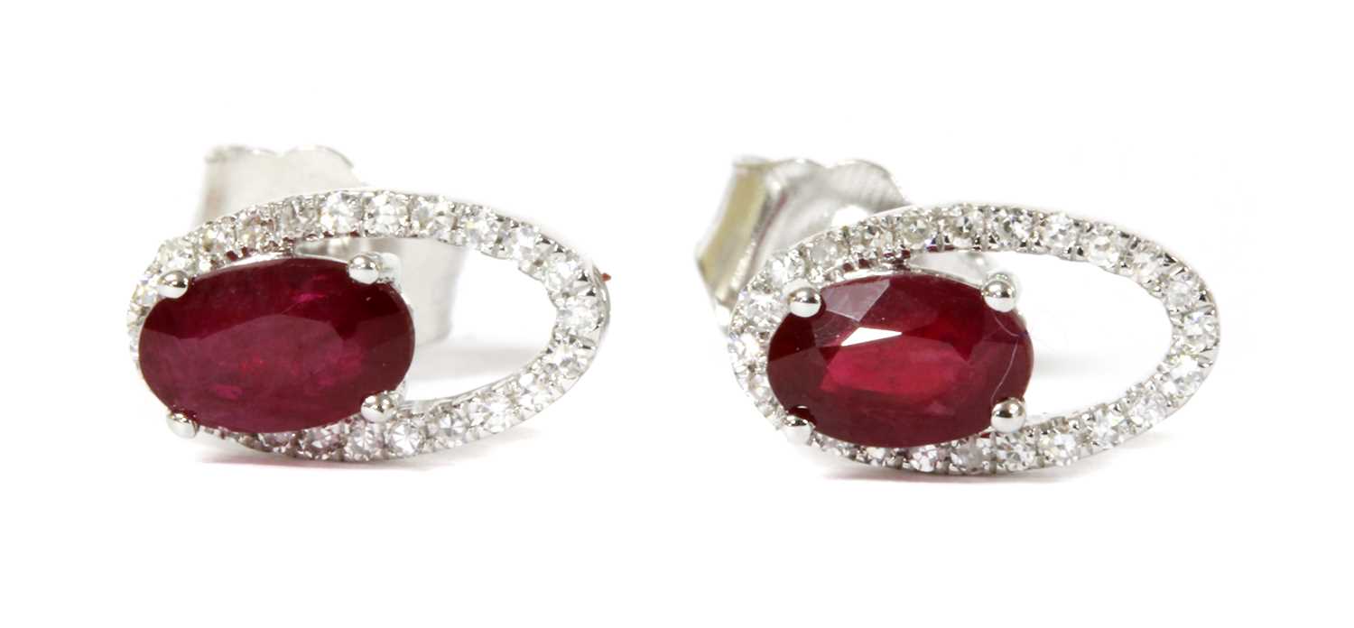 Lot 116 - A pair of white gold ruby and diamond halo stud earrings