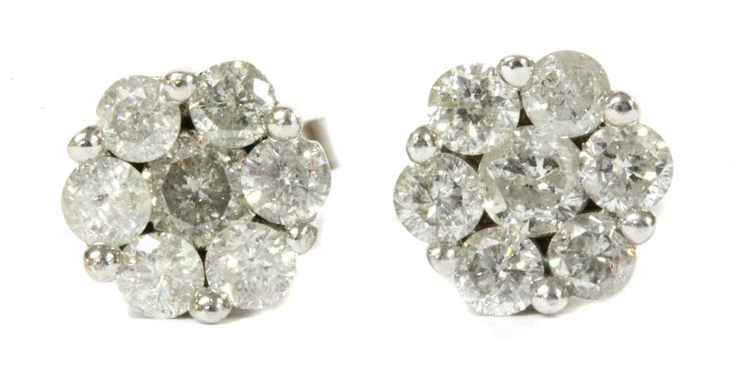 Lot 94 - A pair of white gold diamond daisy cluster earrings