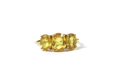 Lot 195 - A gold three stone yellow sapphire ring