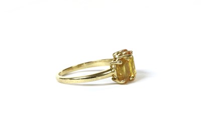 Lot 195 - A gold three stone yellow sapphire ring