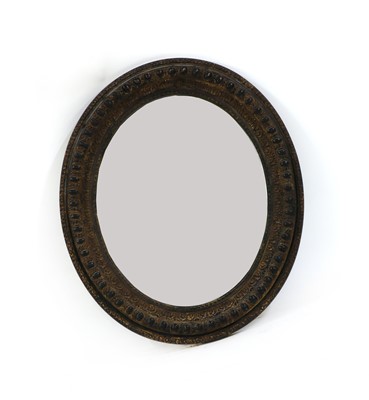 Lot 272 - An ebonised and distressed oval mirror
