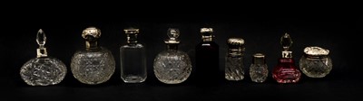 Lot 33 - A collection of cut glass silver topped scent bottles