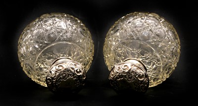 Lot 37 - A pair of globular cut glass silver topped scent bottles