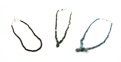 Lot 38 - Three Roman blue/green/black stone & glass bead necklaces.